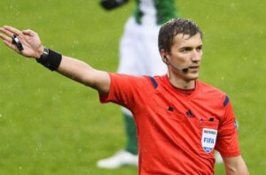 A football referee equipped with a professional earpiece to ensure smooth communication with assistants during the match